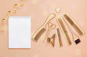 New year background with Golden hair salon accessories. A tree of Hairdresser's tools, scissors, combs, brushes, and an empty white notebook.