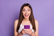 © deagreez - Portrait of excited brown haired girl hold phone unexpected good information blog isolated on purple color background