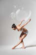 © Artem Popov - ballerina bending down with soap bubbles