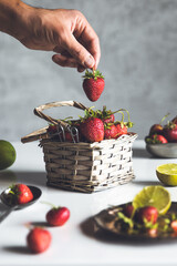 Wall Mural - fresh strawberries in a basket on a white wooden table