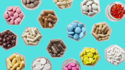 Wall Mural - Medical capsules and pills in hexagonal jars on blue background