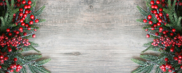 Wall Mural - christmas background with rustic evergreen pine branches and red berries over wood, holiday backgrou