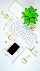 Wall Mural - Stylish white and gold theme desktop workspace with keyboard, notebooks and smart phone. Top view blog hero header creative composition flat lay.