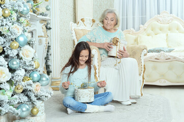 Poster - Smiling little girl with grandmother preparing for Christmas