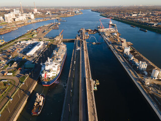 Aerial drone view of a big sluice sea port going towards Amsterdam near Ijmuiden and Velsen Noord a ship going thorugh the largest sluice in the world