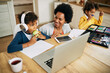 © Drazen - Happy black single mother enjoying with her children during homeschooling.