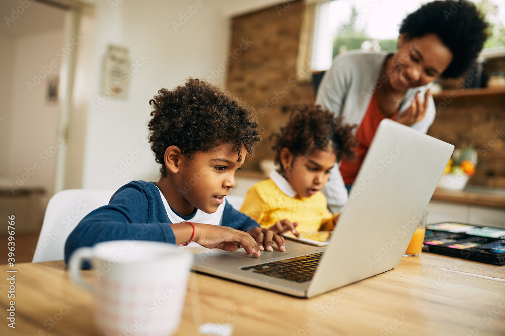 Cute African American boy using laptop at home. Stock Photo | Adobe Stock