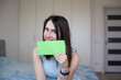© pijav4uk - Smiling girl holding sheet of green paper for your text. Happy woman showing empty white card for simple text