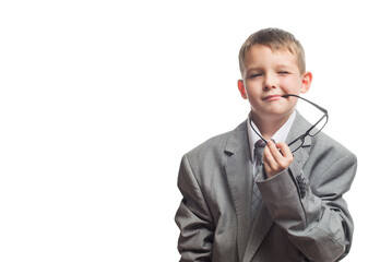 Serious child dressed in a business suit as a businessman holds glasses. Child in adult business suit isolated on white background. Business concept