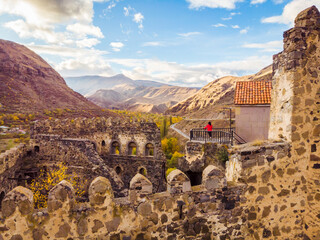 Female tourist stands on top of Khertvisi fortress and looks to stunning landscape panorama  in Vardzia. Travel copyspace background.