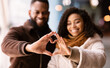 © Prostock-studio - Portrait of black couple making heart shape with hands