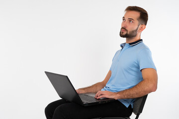 Poster - sitting man with a laptop. a man sits on a chair and holds a laptop on his lap. the guy with the lap