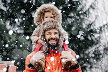 Happy Loving Family! Father And His Baby Are Playing And Hugging Outdoors. Little Child And Daddy On Snowy Winter Walk In Nature. Concept Of The First Long-awaited Winter Snowfall