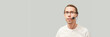 Men in call center. White t-shirt. Headset for telemarketing. Male manager helps customer. Phone operator. Studio portrait. Person multi language translator. Grey background.