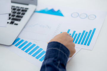 Hand of young business man pointing document data graph and chart paper, marketing and investment, report of statistics profit for financial, economic and growth of finance, management and planning.