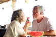 © sutthichai - Retired senior couple enjoying meal in restaurant.