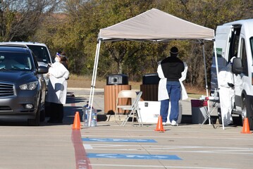 Cars line up at the Covid-19 testing site for drive-thru testing. People await to receive nasal swab tests for COVID-19. 