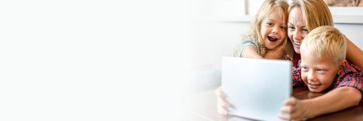 Blonde mom and kids making a video call on a tablet text space banner