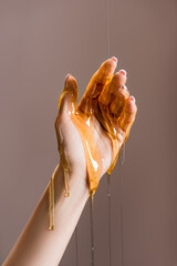 Wall Mural - cropped view of female hand in honey isolated on grey, stock image