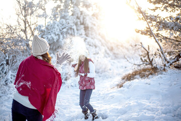 Happy family walking and playing outdoor in the snow winter day