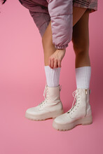 Cropped View Of Female Legs In Boots And Socks On Pink 