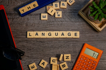 Alphabets spelled LANGUAGE flat lays on wooden background layouts.