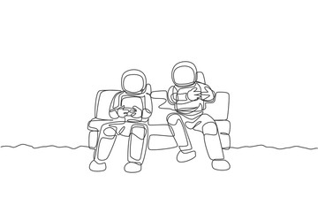 Poster - One single line drawing two young happy astronauts siting on sofa and playing video game in moon surface graphic vector illustration. Cosmonaut outer space concept. Modern continuous line draw design
