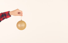 Single Large Golden New Year Ball For The Christmas Tree In Hand On A White Background: Space For Text