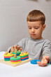 © Мария Чичина - The boy is playing in his room. Learning shapes and colors. A child plays with a sorter. Educational logic toys for kid's. Montessori Games for Child Development.