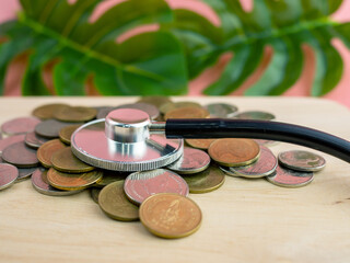 A stethoscope placed on a pile of money is a financial exam concept