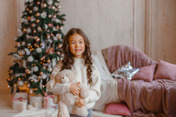 Wall Mural - girl with christmas tree hold bear Teddy