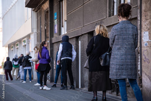 Coronavirus pandemic effects: People stand in long queues to enter the post office and pay bills. Corona virus, Covid-19. Belgrade, Serbia - 10.04.2020