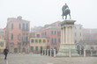 Ancient beautiful square with an equestrian statue and buildings in Venice, Italy, foggy weather. Splendid medieval architecture, detail.