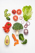 © Anna Puzatykh - Creative layout made of variety of vegetables for making salads. Carrots, lettuce, kale, tomato, cucumber, broccoli, avocado, red bell pepper, onion.  White background, top view, copy space
