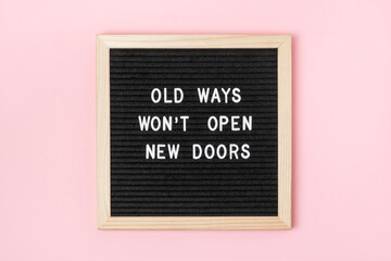 Wall Mural - Old Ways Won't Open New Doors. Motivational quote on black letter board on pink background. Concept inspirational quote of the day. Greeting card, postcard