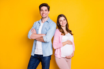 Canvas Print - Photo of beautiful family waiting baby mommy hugging tummy father arms crossed isolated yellow color background