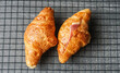 Top view of Croissants on a cooling rack on textured grey background