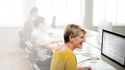 Wall Mural - Middle aged woman working on a computer