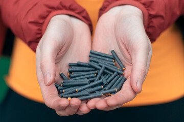 Wall Mural - Man Holding Small Black Firecrackers in his Hand. Guy Getting Ready for New Year Fun - CloseUp Shot