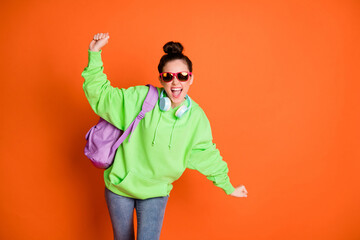 Canvas Print - Photo portrait of excited dancing schoolgirl with open mouth isolated on vivid orange colored background