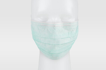 Wall Mural - Green disposable surgical face mask on a mannequin