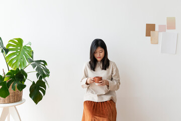 Poster - Asian woman with a cup of coffee in her hand