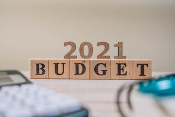 Budget 2021 concept. 2021 budget wooden cubes, calculator and a pen on wooden office table.