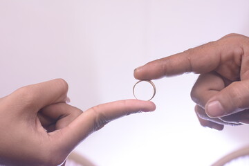 Wall Mural - a man's hand inserts a ring on the finger of the bride