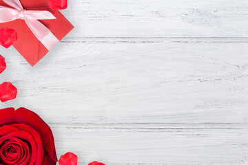 Wall Mural - Valentines background with red rose and valentine envelope on the wooden table, flat lay with copy space, left border