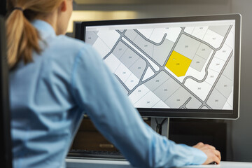 Wall Mural - woman working with digital cadastral map land register database on computer in office