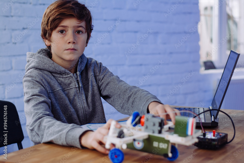 The boy is programming on a laptop. Scratch robot programming. Gigo ...