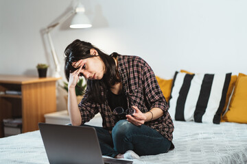Fatigue toung woman in plaid shirt rubbing face while watching computer laptop totally exhausted working late at night. Achievement business career and overtime work concept