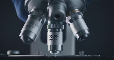 Wall Mural - close-up shot of sample slide and microscope with metal lens at laboratory.