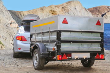 Canvas Print - Car with a trailer and an autobox on a trot on the lake shore